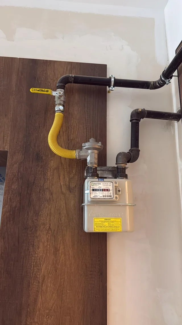 Duvara yerleştirilmiş gaz sayacı, vana ve çevresindeki boru bağlantıları